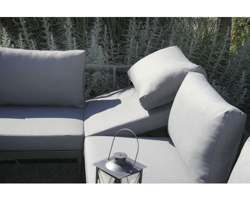 Nahaufnahme einer grauen Gartenlounge mit Kissen und einer Laterne