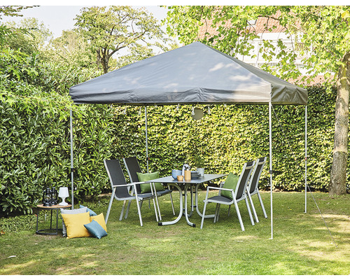 Gartenszene mit Pavillon, Gartentisch und Stühlen auf einer Rasenfläche