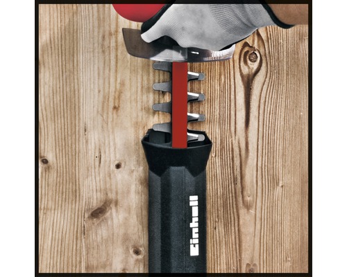 Einhell Heckenschere im Einsatz mit Handschuh vor Holzwand