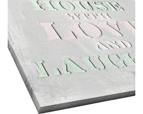 Dekoratives Schild mit dem Spruch: Haus mit Liebe und Lachen.