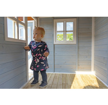 Kind in einem Spielhaus aus Holz mit Fenster und Tür