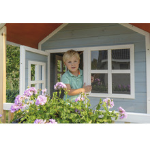 Kind im Holzspielhaus mit Fenster und Blumenkasten