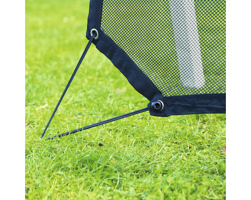 Detailaufnahme eines Fußballtors mit Netz und Befestigungselementen auf einer Rasenfläche.