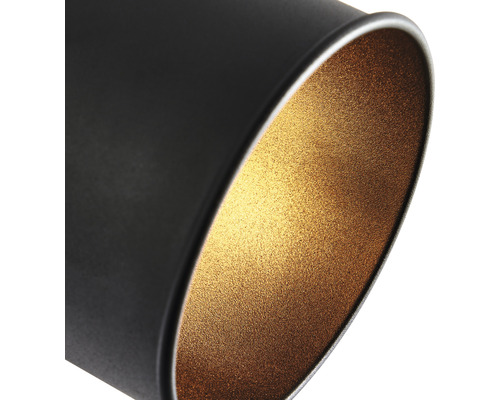 Nahaufnahme einer schwarzen zylindrischen Leuchte mit goldfarbener Innenseite.