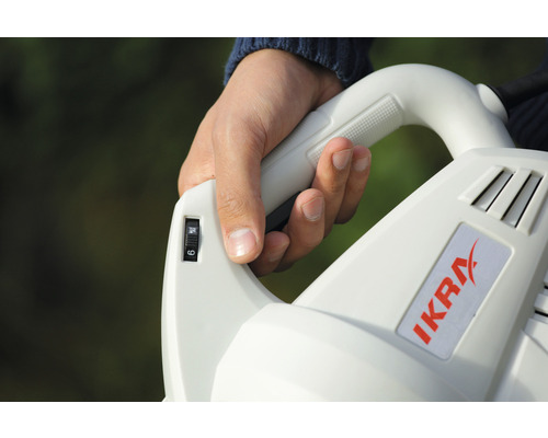 Nahaufnahme einer Hand, die einen Laubbläser der Marke Ikra bedient und die Geschwindigkeitsstufe einstellt.