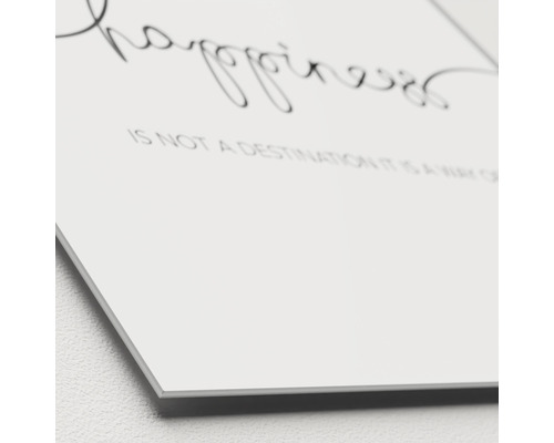 Nahaufnahme einer Wanddekoration mit dem Zitat Glück ist kein Ziel, sondern eine Art zu reisen.