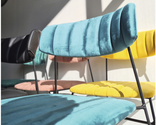 Mehrere Stühle mit Stoffbezug und Metallbeinen stehen im Raum.