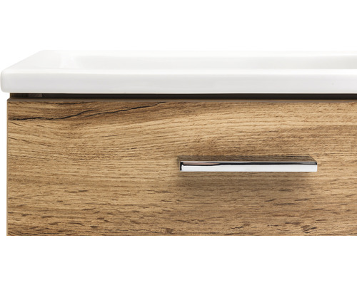 Detailaufnahme eines Waschtischunterschranks mit Holzoptik und einem Griff.