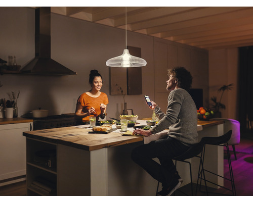 Hängelampe über Esstisch in moderner Küche mit zwei Personen