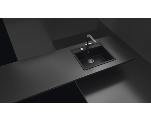 Schwarze Küchenspüle mit Wasserhahn auf einer Küchentheke.