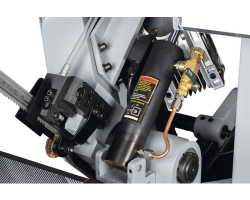 Detailansicht einer Metallsäge mit Hydraulikzylinder und Kühlmittelzufuhr