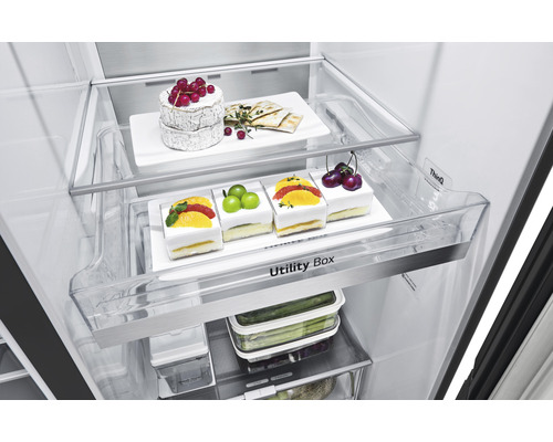 Blick in einen Kühlschrank mit Käse, Gebäck, Obst und Gemüse in Aufbewahrungsboxen