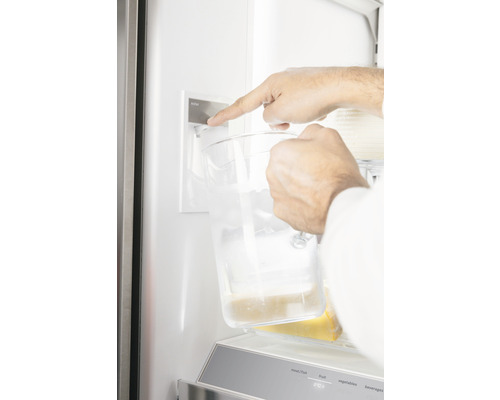 Entnahme von Wasser aus einem Kühlschrank mit Wasserspender in einen Krug