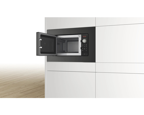 Eingebaute Mikrowelle mit geöffneter Tür in einer modernen Küche.