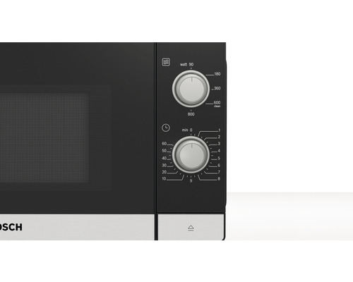 Nahaufnahme einer Mikrowelle mit Drehknöpfen für Watt und Zeit