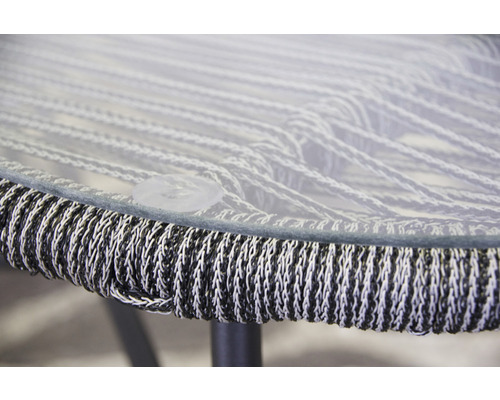 Detailansicht eines Gartentisches mit Glasplatte und geflochtenem Rand