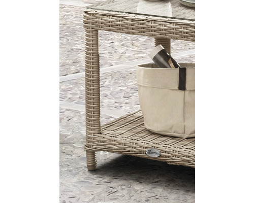 Detailansicht eines Rattantisches mit Glasplatte und Ablagefläche mit Zeitschriftenhalter