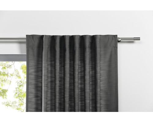 Grauer Vorhang an einer Gardinenstange vor einem Fenster.