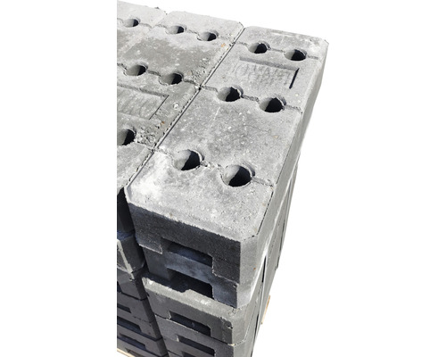 Graue Rasenbordsteine im Stapel, aus Beton mit Löchern