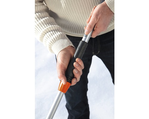 Person hält einen Schneeschieber mit Teleskopstiel in der Hand