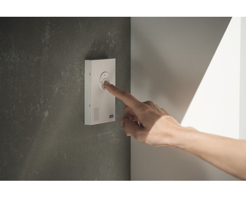 Person bedient Lichtschalter an der Wand