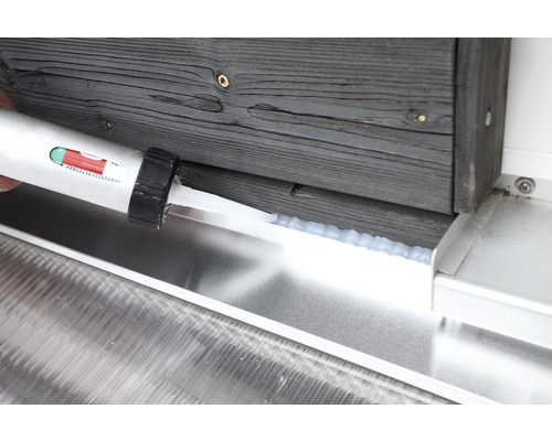 Auftragen von Dichtmasse zwischen Holz und Metall mit einer Kartuschenpistole