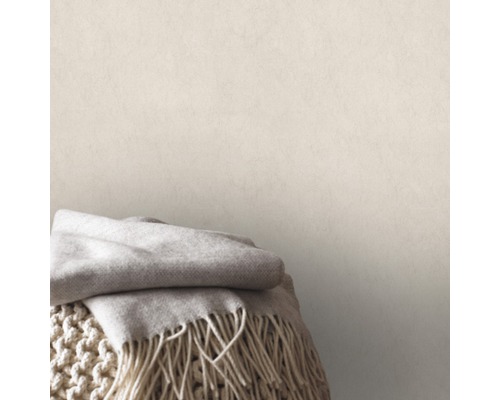 Wohnszene mit Wolldecke auf Strickhocker vor einer Wand