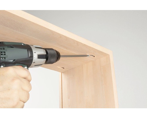 Akkuschrauber beim Einschrauben einer Schraube in ein Holzmöbel