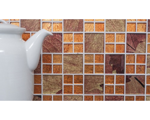 Detailaufnahme eines Mosaiks mit Blattmotiven neben einer Teekanne