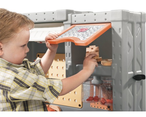 Kind spielt mit einer Werkbank für Kinder mit Werkzeug und Schrauben