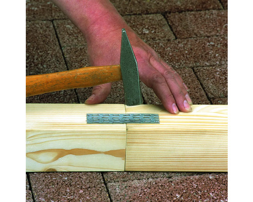 Eine Person befestigt eine Holzverbindung mit einem Hammer.