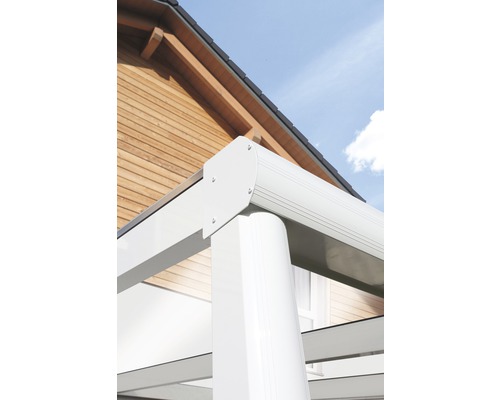 Detailansicht einer Terrassenüberdachung mit weißer Rahmenkonstruktion vor einem Haus mit Holzfassade