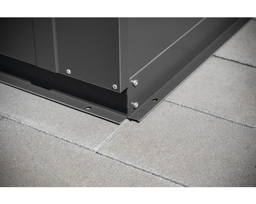 Detailaufnahme einer Gerätehaus-Ecke mit Befestigung auf Pflastersteinen