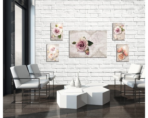 Wohnzimmer mit weißen Sesseln, Tisch und Wandbildern mit Rosenmotiven an einer Ziegelwand