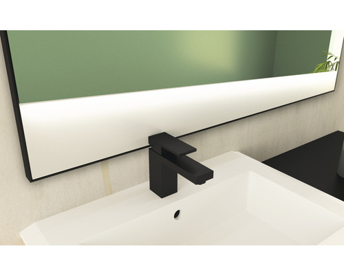 Waschbecken mit schwarzer Armatur und Spiegel mit Beleuchtung