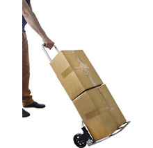 Eine Person transportiert zwei Kartons mit einem Rollwagen.