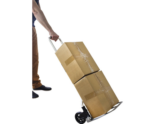 Eine Person transportiert zwei Kartons mit einem Rollwagen.