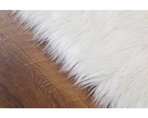 Detailansicht eines weißen Teppichs auf Holzboden