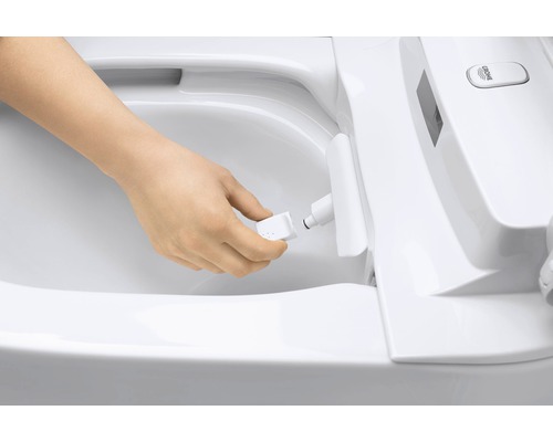 Eine Person wechselt die Düse einer Duschtoilette aus.