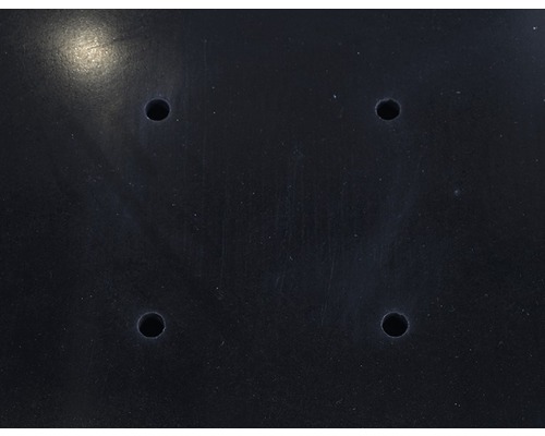 Schwarze Oberfläche mit vier Bohrlöchern