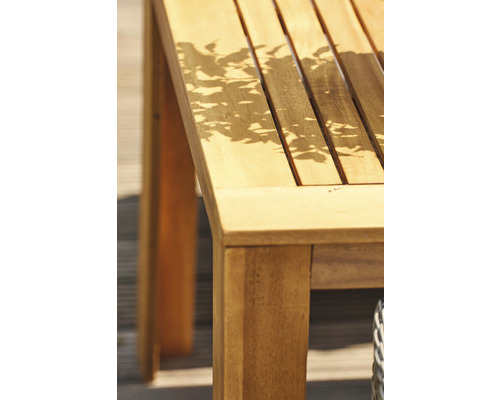 Detailansicht eines Gartentisches aus Holz mit Schattenmuster