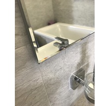 Detailansicht eines Badezimmerspiegels mit Waschtisch und Armatur
