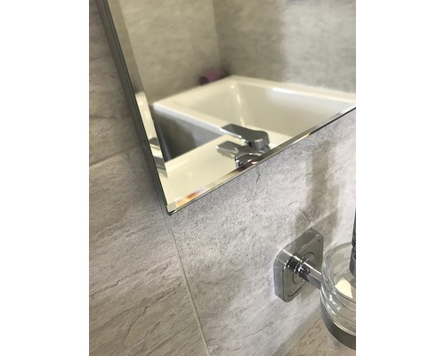 Detailansicht eines Badezimmerspiegels mit Waschtisch und Armatur