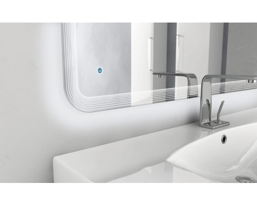 Detailaufnahme eines Badezimmerspiegels mit Beleuchtung über einem Waschbecken mit Armatur