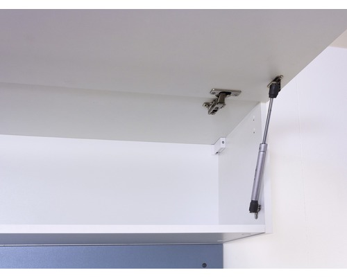 Innenansicht eines weißen Küchenschranks mit Scharnieren und Gasdruckfeder