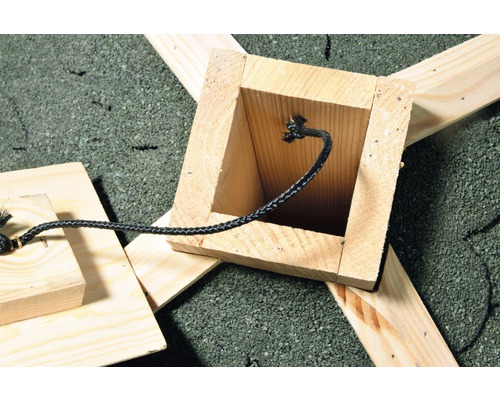 Holzkonstruktion mit schwarzer Kordel auf Kiesuntergrund