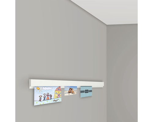 Wandleiste zur Präsentation von Fotos und Zeichnungen an einer grauen Wand