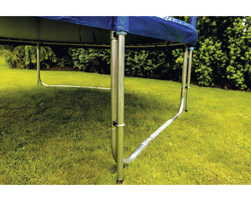 Detailansicht eines Trampolins mit Metallbeinen im Garten.