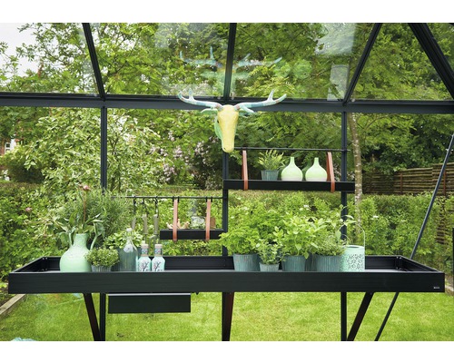 Gewächshaus mit Tisch und Dekoration im Garten