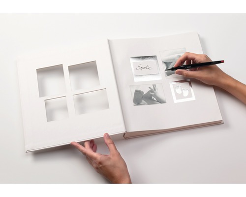 Offenes Fotoalbum zum Selbstgestalten mit Stift in der Hand